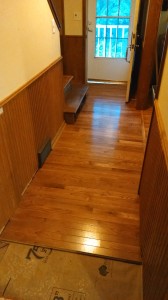 The first steps begin at the front door... two layers of old vinyl plus the plywood subfloor were cut out and new hardwood nailed to the diagonal planks.